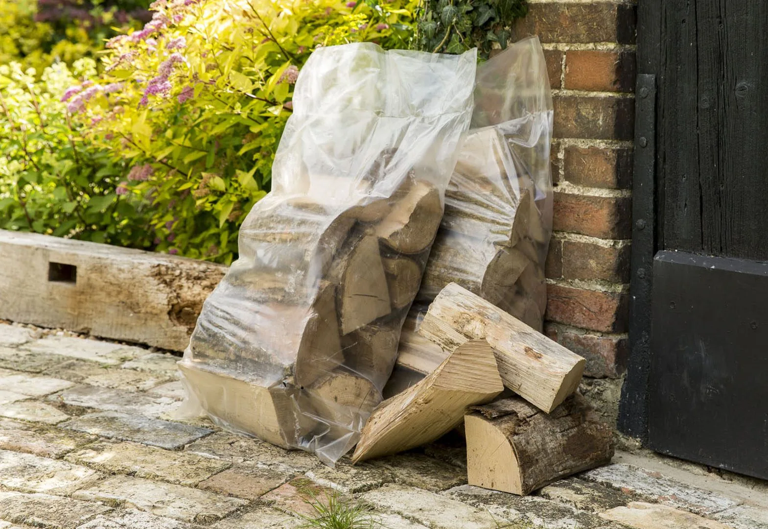 Bags of firewood logs in a garden